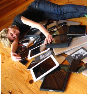 lying with numerous tech devices